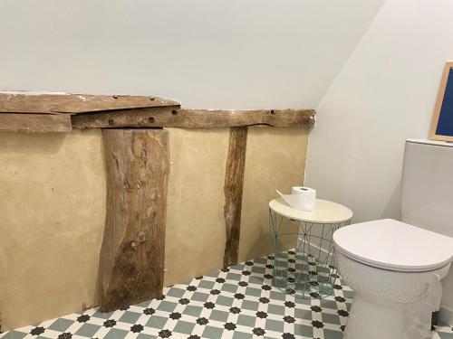 La salle de bains est pourvue de toilettes et d'une table. dans l'établissement La petite ferme de Roumare, à Roumare