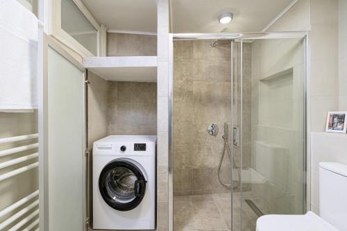 y baño con lavadora y ducha. en The H Experience - The Good Life Archanes - Free parking, en Archanes