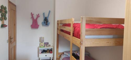 a bedroom with two bunk beds with red sheets at Appartamento Arcobaleno in Folgaria