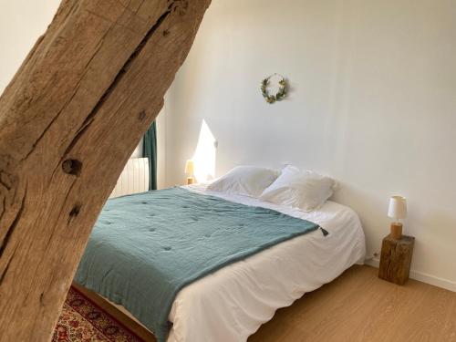 - une chambre dotée d'un grand lit avec une poutre en bois dans l'établissement La petite ferme de Roumare, à Roumare