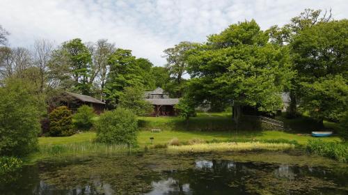 une maison et un étang en face d'une maison dans l'établissement Ta Mill Cottages & Lodges - Brookview Lodge 2, à Launceston