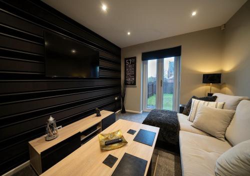 ein Wohnzimmer mit einem Sofa und einem Flachbild-TV in der Unterkunft The Hideaway Sherburn in Elmet in Sherburn in Elmet
