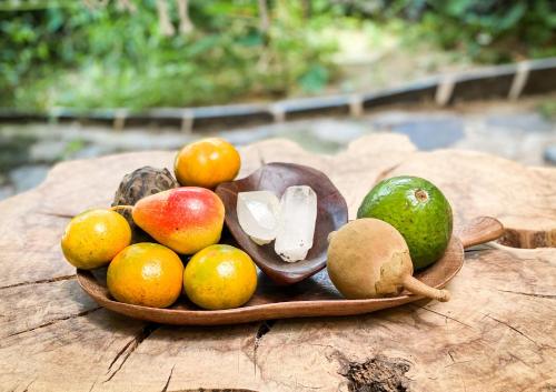 a wooden plate of fruit on a wooden table at Unicorn Reborn - Peaceful Rentals in San Marcos La Laguna