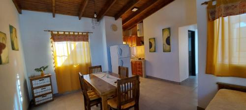 La cuisine est équipée d'une table, de chaises et d'un réfrigérateur. dans l'établissement DEPARTAMENTO ORTEGA Junin, à Junín