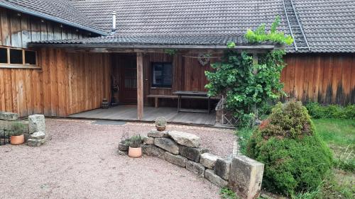 a backyard with a bench and a stone wall at Herberge an den Gärten in Lauchröden