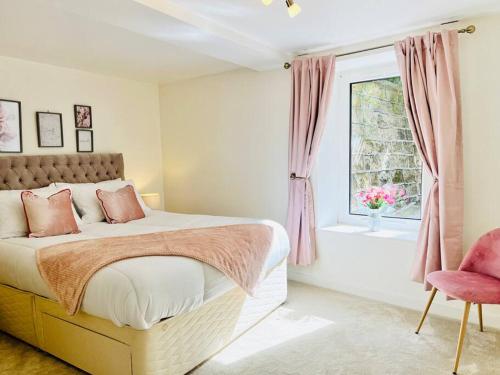 a bedroom with a bed and a window and a chair at The Ilkley Hideaway in Ilkley