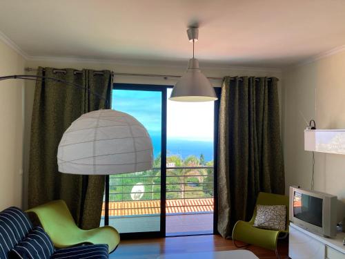 una sala de estar con una gran puerta corredera de cristal en Ponta do Sol Amazing 3 Bedroom Apartment, en Ponta do Sol