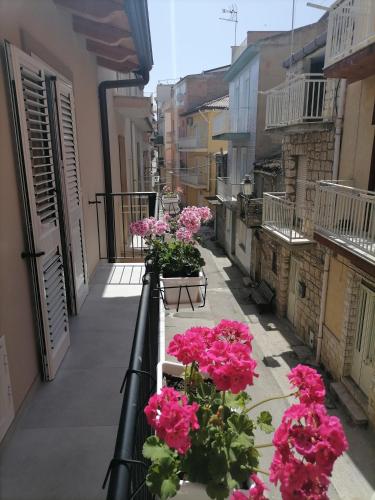 a balcony with pink flowers on a city street at SoleLuna Apartment 2 in Santa Elisabetta