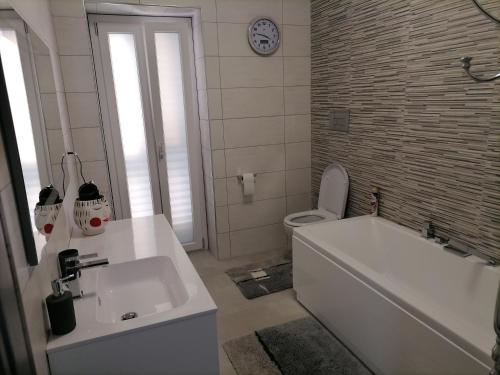 a bathroom with a tub and a toilet and a sink at SoleLuna Apartment 2 in Santa Elisabetta