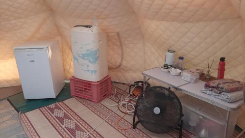 a room with a heater and a table in a tent at אוהל הזית in Maʼor