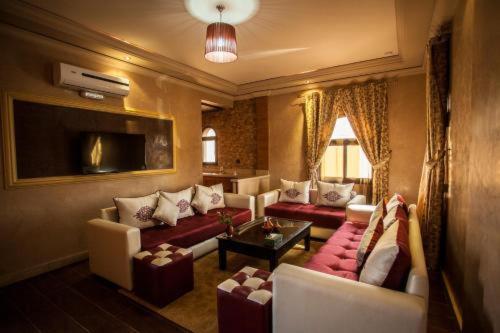 Una sala de estar con un sofá y sillas y una mesa. en Toubkal appart hotel, en Tahannout