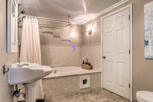 a white bathroom with a tub and a sink at Bel Air Apartment with Pool about 2 Mi to Main St in Bel Air