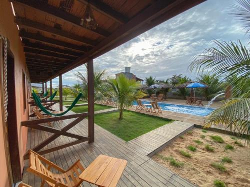 a deck with a hammock and a swimming pool at Pousada Brisa do Mar in Barrinha