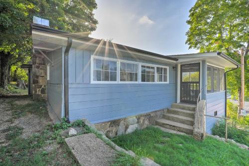 a blue house with a porch and stairs in a yard at 11 Mi to Dtwn Branson Cottage in Rockaway Beach! in Rockaway Beach