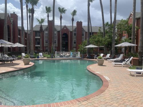a swimming pool with chairs and umbrellas in a resort at Spacious 2BR&2BA Med Center APT, Free parking&shuttle in Houston