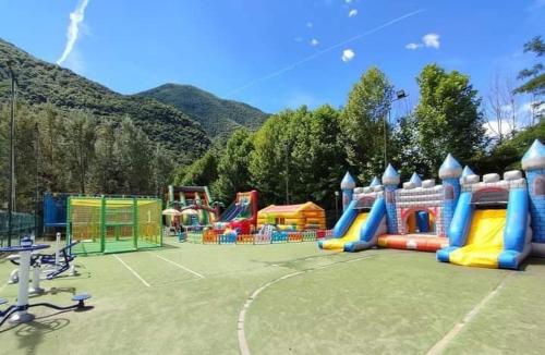 um parque infantil com um campo de jogos colorido em Chalet Rent Porlezza em Porlezza