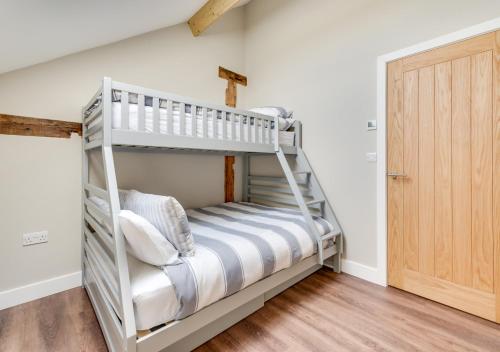 a bunk bed in a room with a ladder at The Cartlodge in Woolpit