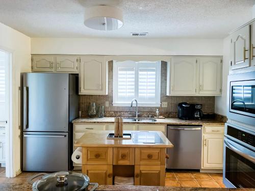 a kitchen with white cabinets and a stainless steel refrigerator at The Mini Mansion at Graceland in Memphis