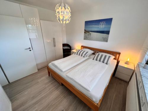 a bedroom with a large bed and a chandelier at Veens Crew Home 4 Pax in Dreieich