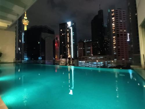 a swimming pool with a city skyline at night at City Home Suites Kuala Lumpur City Centre in Kuala Lumpur
