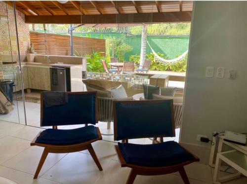 2 stoelen in een woonkamer met uitzicht op een patio bij Casa Pé na Areia in Pauba