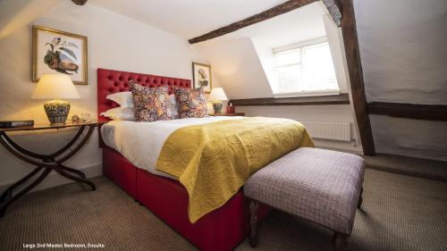 um quarto com uma cama, uma mesa e uma janela em The Sherborne Cottage em Sherborne