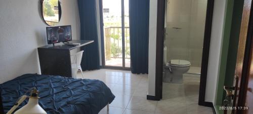 a bathroom with a bed and a toilet in a room at Hotel Venta El Puerto in Murcia