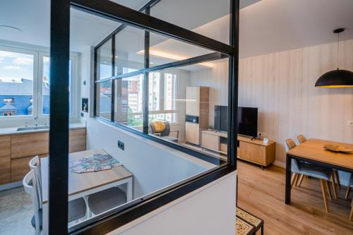 ブルゴスにあるCid Campeador I - Apartamentos Burgos Deluxeの大きな窓とダイニングテーブルが備わる客室です。