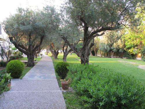 a walkway in a park with trees and grass at Florida Blue Bay Resort & Spa in Psathopirgos