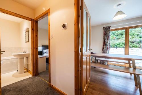 uma casa de banho com uma mesa e um lavatório num quarto em Langridge Highland Home em Badcaul