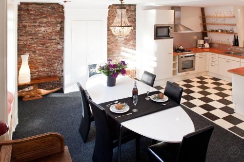 a kitchen and dining room with a white table and chairs at Canal Holiday Apartment in Amsterdam