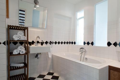 Canal Holiday Apartment في أمستردام: حمام أبيض مع حوض ومغسلة