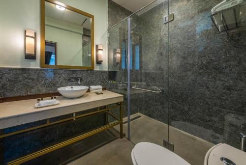 a bathroom with a sink and a glass shower at Hotel Eagles Nest in Dharamshala