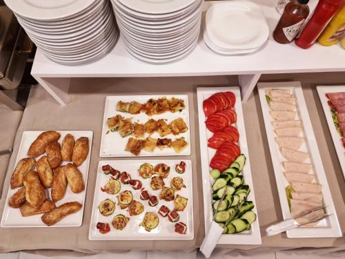 a table with several trays of different types of food at Senator Hotel in Tirana
