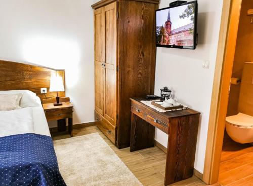 a bedroom with a bed and a desk and a tv at Etno Garden Apartments in Plitvička Jezera