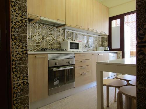 a kitchen with a stove and a microwave at Casa Encantada - Benfica in Lisbon