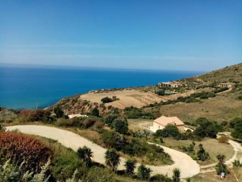 a road on a hill with the ocean in the background at SoleLuna Apartment 2 in Santa Elisabetta
