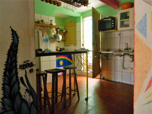 - une cuisine avec un comptoir et des tabourets dans une pièce dans l'établissement Jahostel, à Lençóis