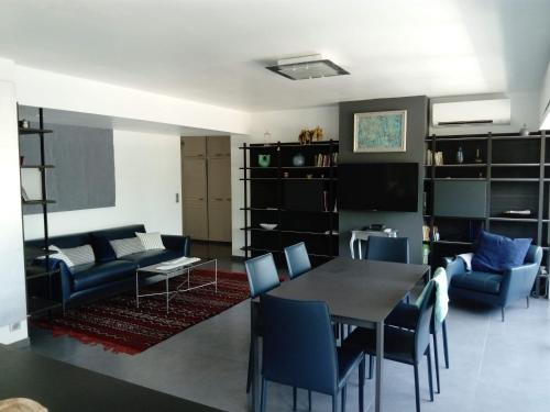 a living room with a dining room table and chairs at Bel appartement 3 chambres vue port de Golf Juan in Vallauris