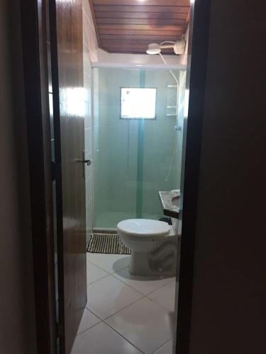 uma casa de banho com um WC e uma porta de vidro em TRIPLEX PRAIA DO PERÓ em Cabo Frio