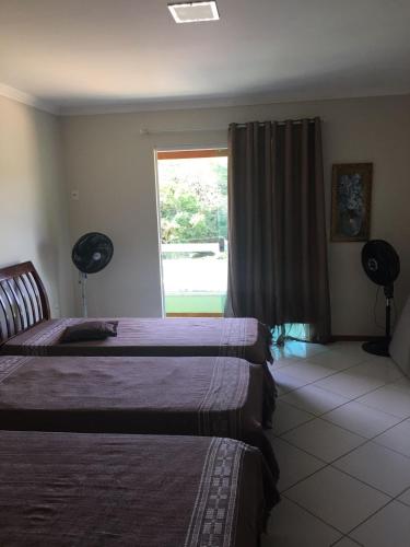um quarto de hotel com duas camas e uma janela em TRIPLEX PRAIA DO PERÓ em Cabo Frio