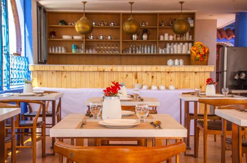 a dining room with wooden tables and chairs at VANCII Hotel in Chefchaouene