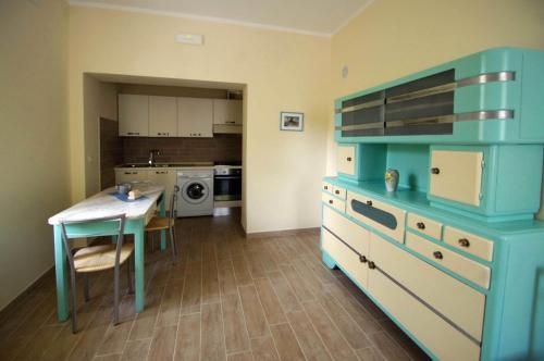 uma cozinha com uma mesa e um armário azul em Il Mulino del Castello em Garlenda