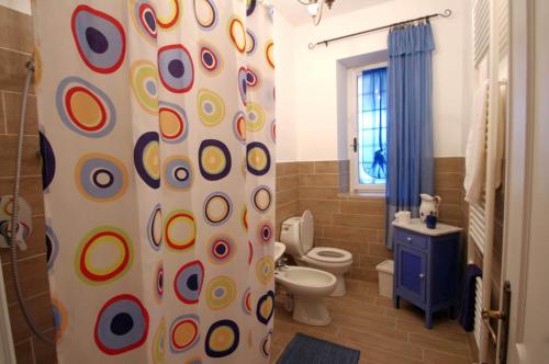a bathroom with a toilet and a shower curtain at Il Mulino del Castello in Garlenda