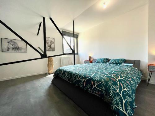 1 dormitorio con 1 cama con edredón verde en Residence Belfort en Le Mans