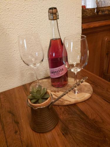 a bottle of wine and two glasses on a table at El Rincón de Pirón in Losana de Pirón