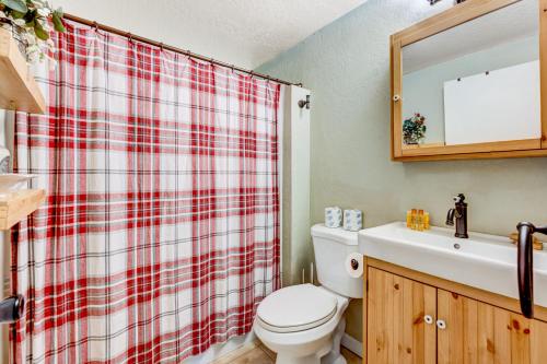 La salle de bains est pourvue d'un rideau de douche rouge et blanc. dans l'établissement Tahoe Treetop Escape, à Stateline