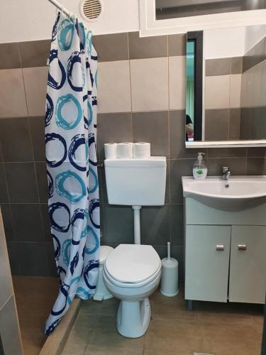 uma casa de banho com um WC, um lavatório e uma cortina de chuveiro em Houses in the Village em Kavala