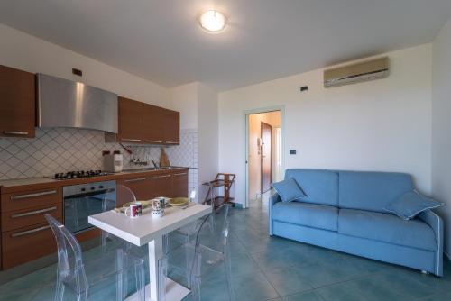 a kitchen and living room with a blue couch and a table at Pepigall vista mare in Alghero