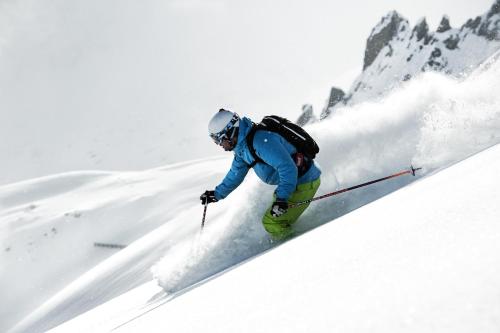 a man is skiing down a snow covered slope at Alpenpension Pfurtscheller in Neustift im Stubaital